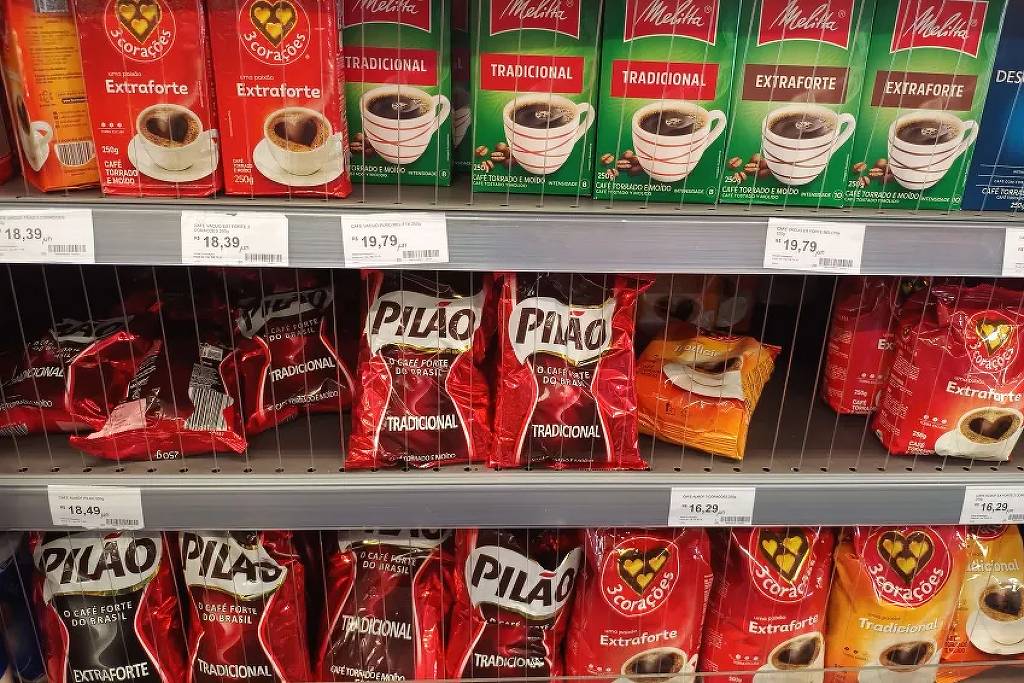 A imagem mostra uma prateleira de supermercado com várias embalagens de café. Na parte superior, há caixas de café da marca Melitta, com as variedades