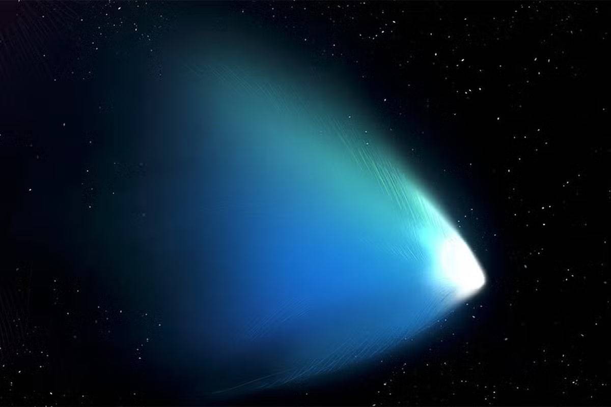 A imagem mostra um cometa se movendo pelo espaço, com uma cauda longa e brilhante que se estende em direção ao fundo escuro do cosmos. A cauda apresenta um gradiente de cores que vai do azul ao branco, destacando-se contra o céu estrelado.