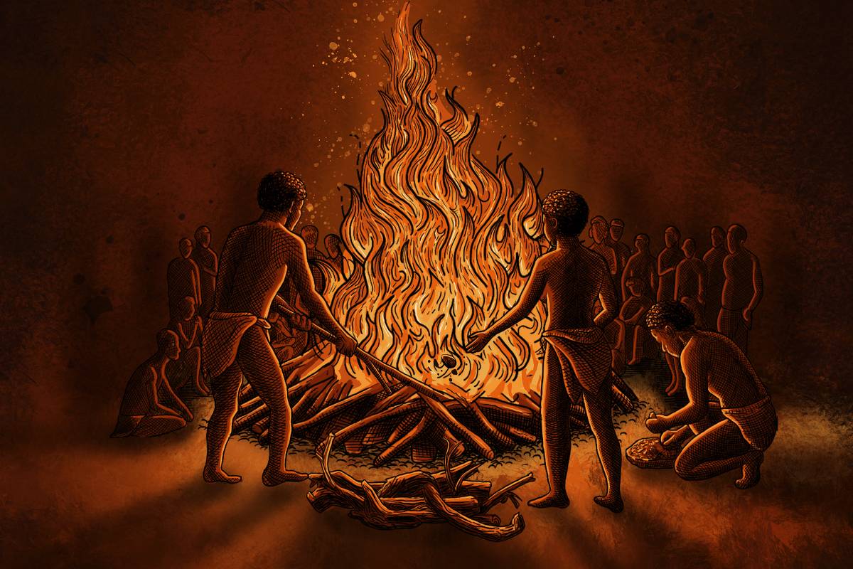 Grupo de pessoas em círculo ao redor de uma grande fogueira acesa. Três indivíduos estão próximos ao fogo, segurando galhos para alimentar as chamas. O ambiente é escuro, iluminado apenas pela luz do fogo, com outras pessoas sentadas ou em pé ao fundo.