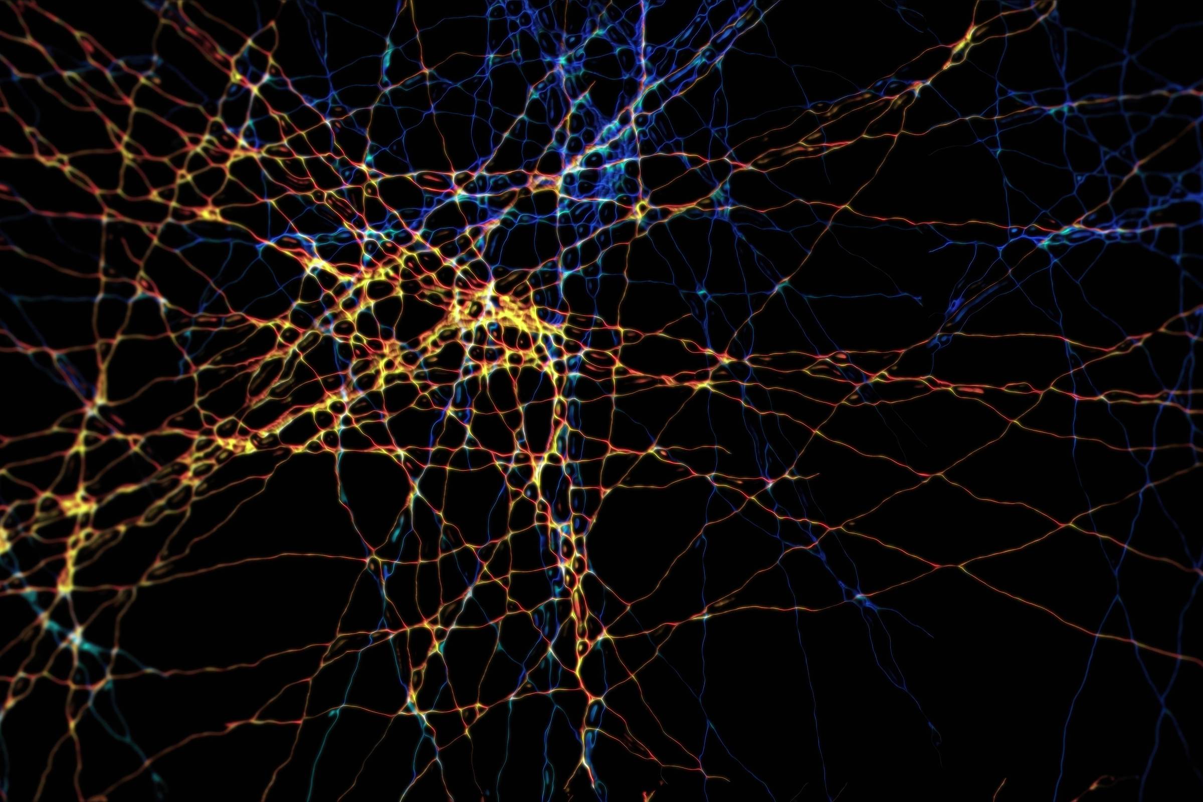 Estrutura complexa de linhas entrelaçadas em tons de azul, amarelo e vermelho sobre fundo preto, simulando conexões neurais ou rede de dados.
