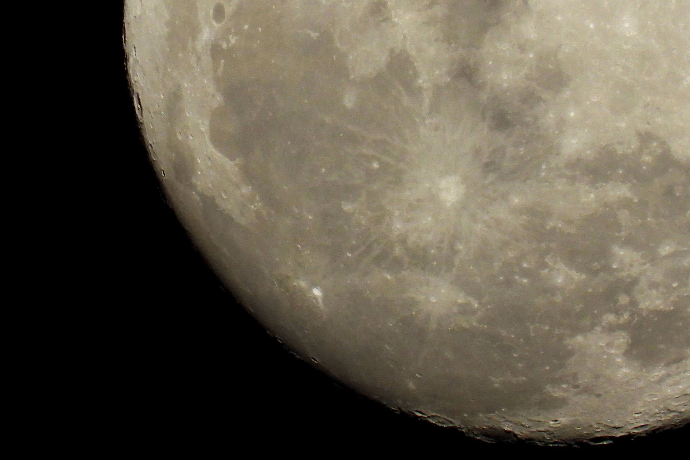 Imagem detalhada da superfície da Lua com crateras visíveis e textura irregular, contra fundo preto do espaço.