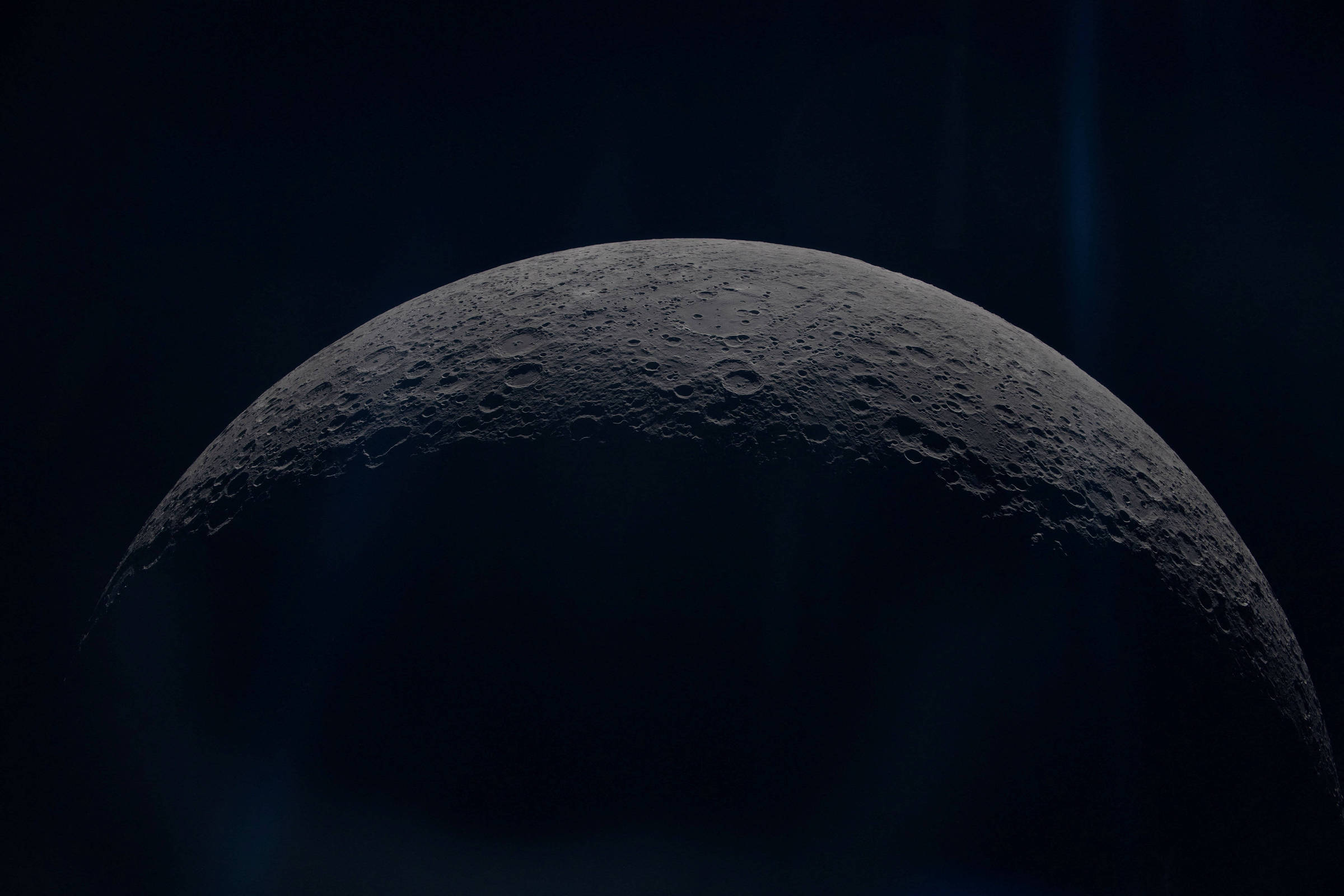 Metade da superfície da Lua visível em detalhe, mostrando crateras e relevo sob iluminação lateral contra fundo escuro.