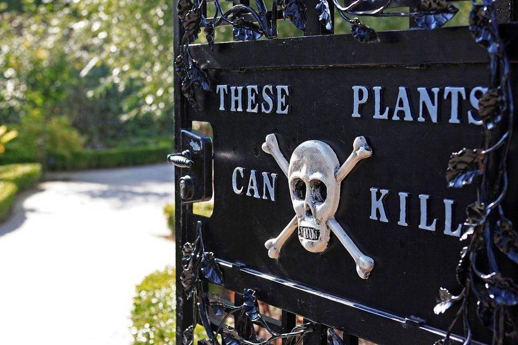 Placa preta em portão de ferro com texto em inglês