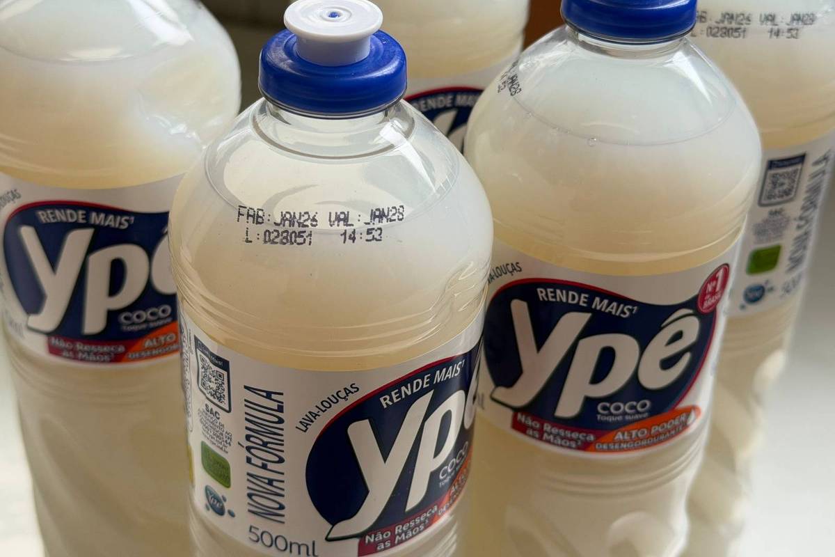 Cinco garrafas transparentes de detergente líquido Ypê coco, com tampa azul, dispostas em superfície clara. Rótulos exibem marca, volume de 500 ml e informações de fabricação.