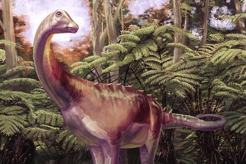 Dinossauro de pescoço longo e corpo robusto em meio a samambaias altas e árvores densas, sob céu parcialmente nublado.