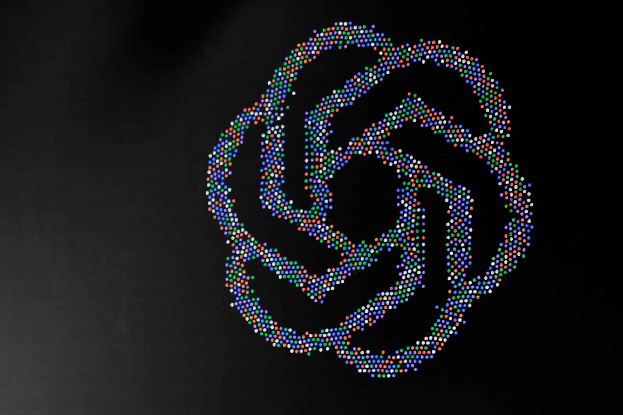 Logotipo colorido da OpenAI projetado à direita